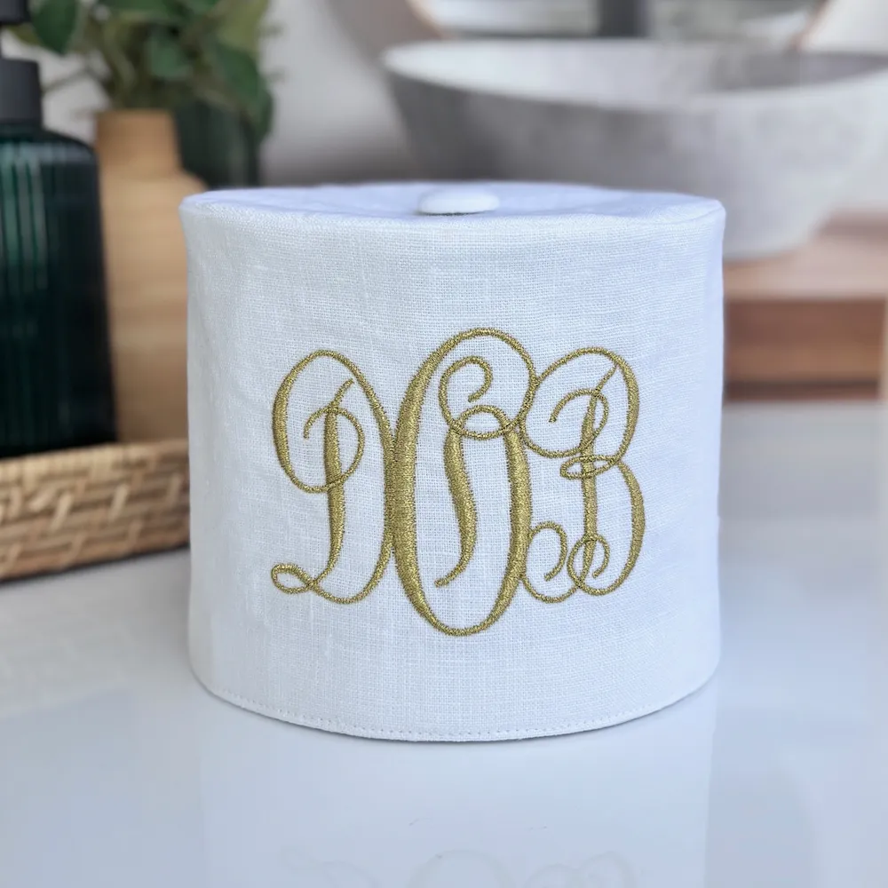 Handmade monogram fabric toilet paper cover in farmhouse style bathroom with coordinating tissue box cover