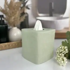 Sage green linen tissue box cover on a farmhouse bathroom vanity