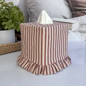 Red and tan ticking stripe tissue box cover on nightstand with plant