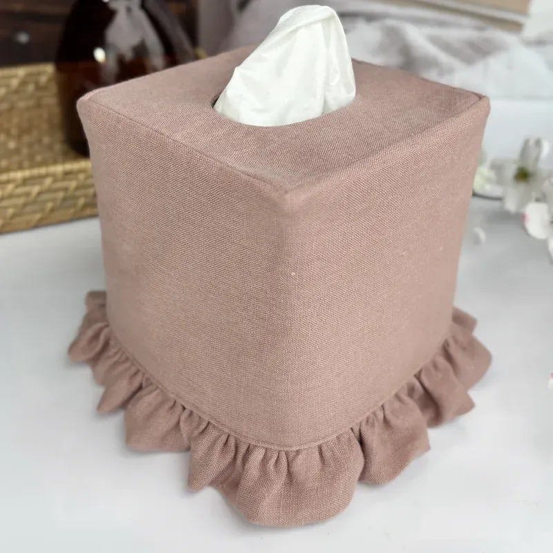 Square dusty mauve pink linen tissue box cover with gathered ruffle hem beside white flowers